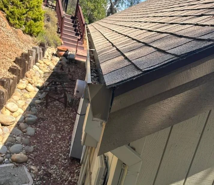 Constricted drainage path between the uphill slope and the Auburn home's exterior wall