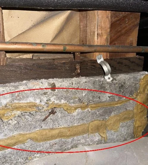 Horizontal crack with earlier sealant-injection material along the concrete crawlspace foundation