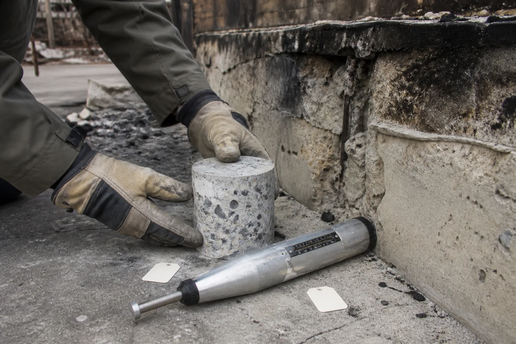 Concrete core sample and rebound hammer used to investigate a fire-exposed foundation